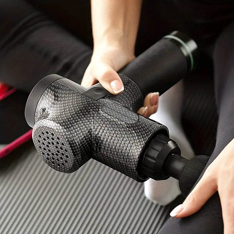 Person holding a black massage gun on a dark background